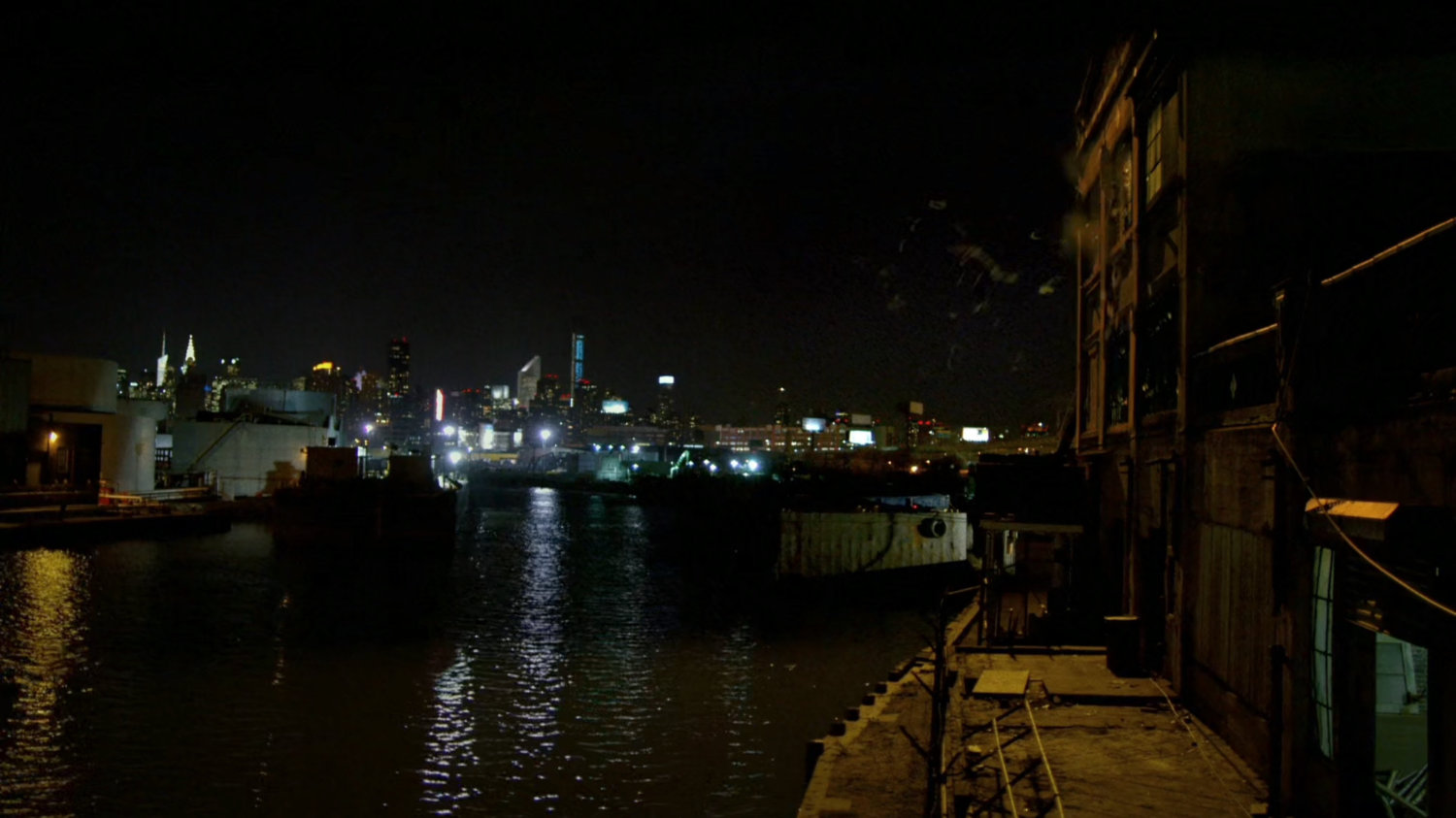 Daredevil leaps from a window of warehouse at Pier 81 at night.