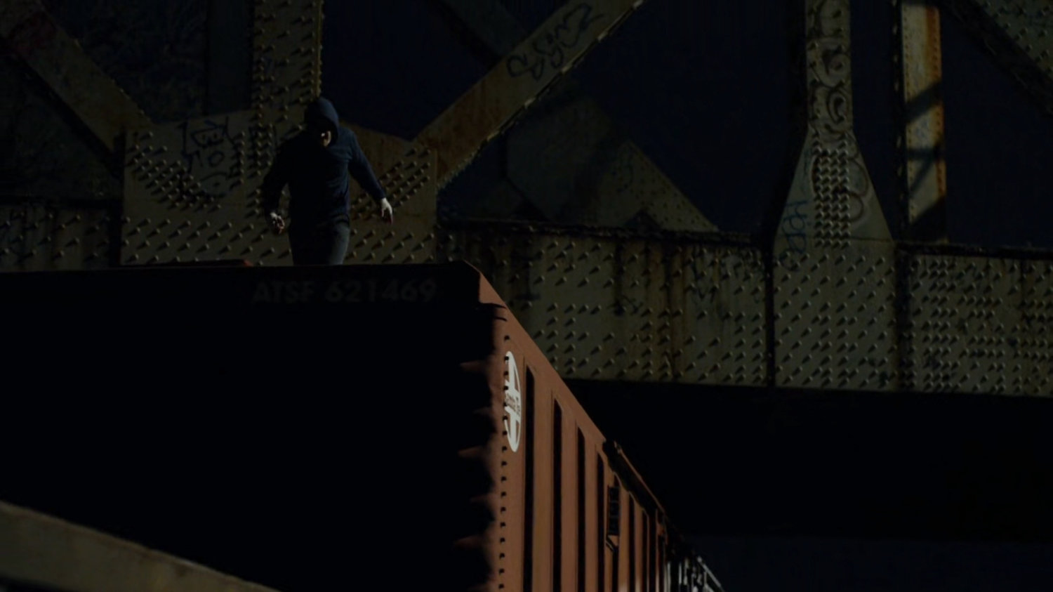 Matt Murdock on top of train car at night.