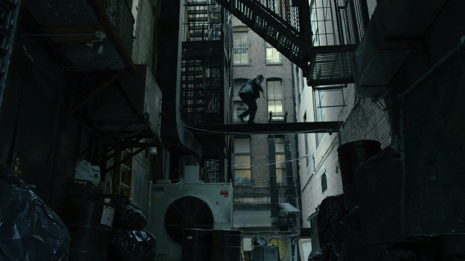 Matt climbs scaffolding in alley.