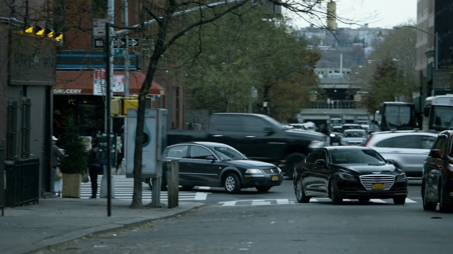 A black sedan turns a New York street corner.