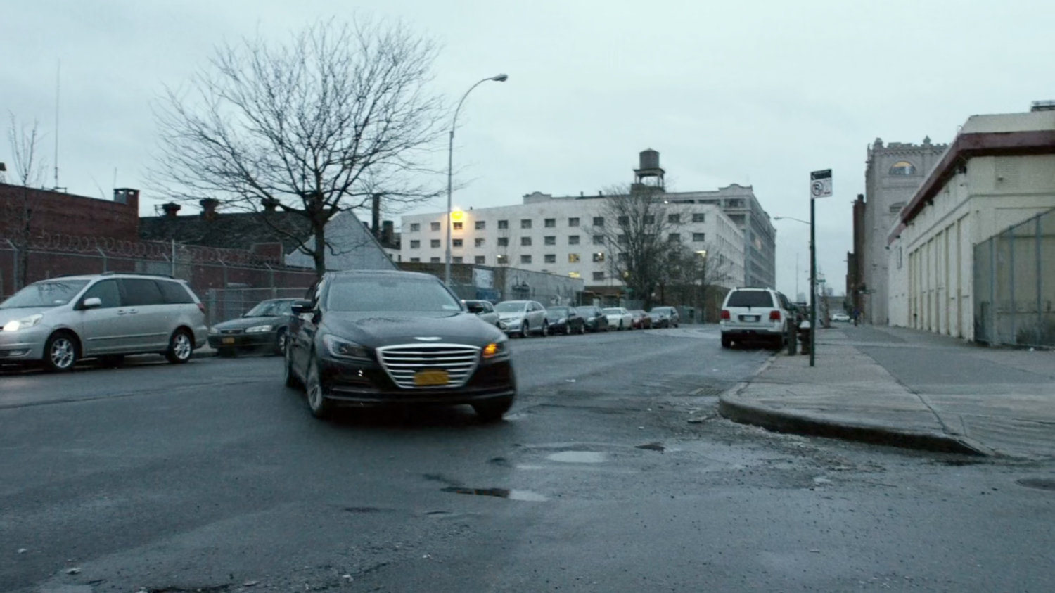 A black sedan turns a New York street corner.