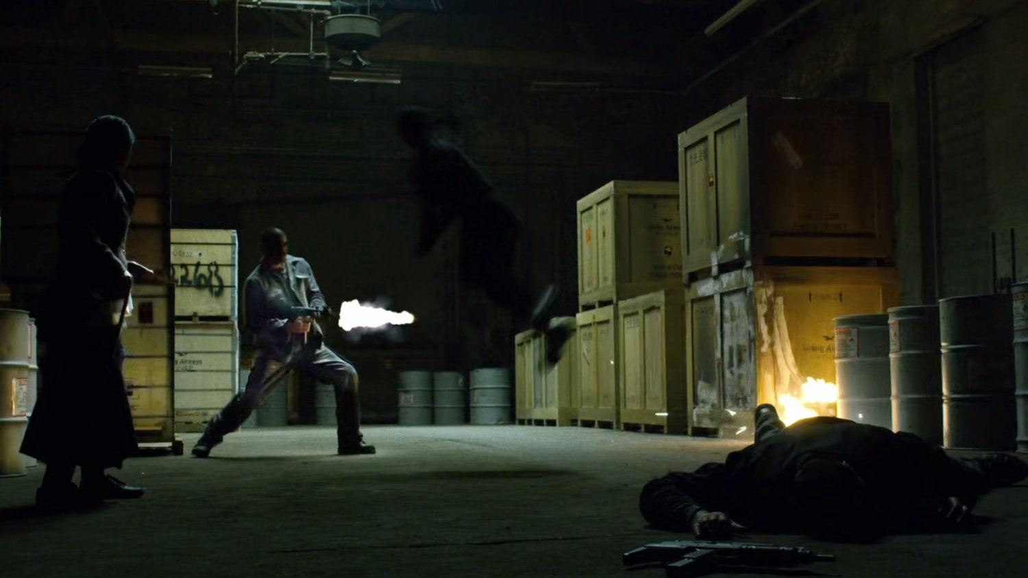 The man in black fights thugs inside Gao's warehouse.