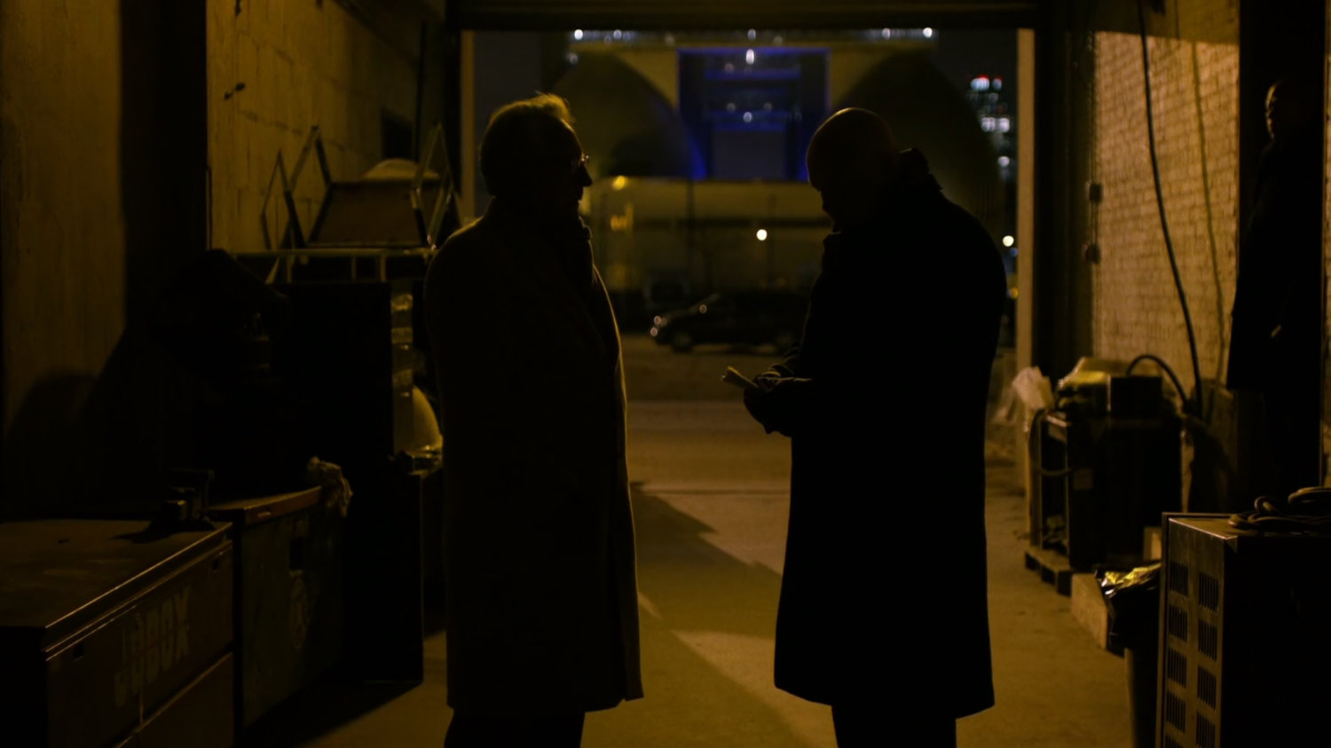 Leland and Fisk inside a dark garage.