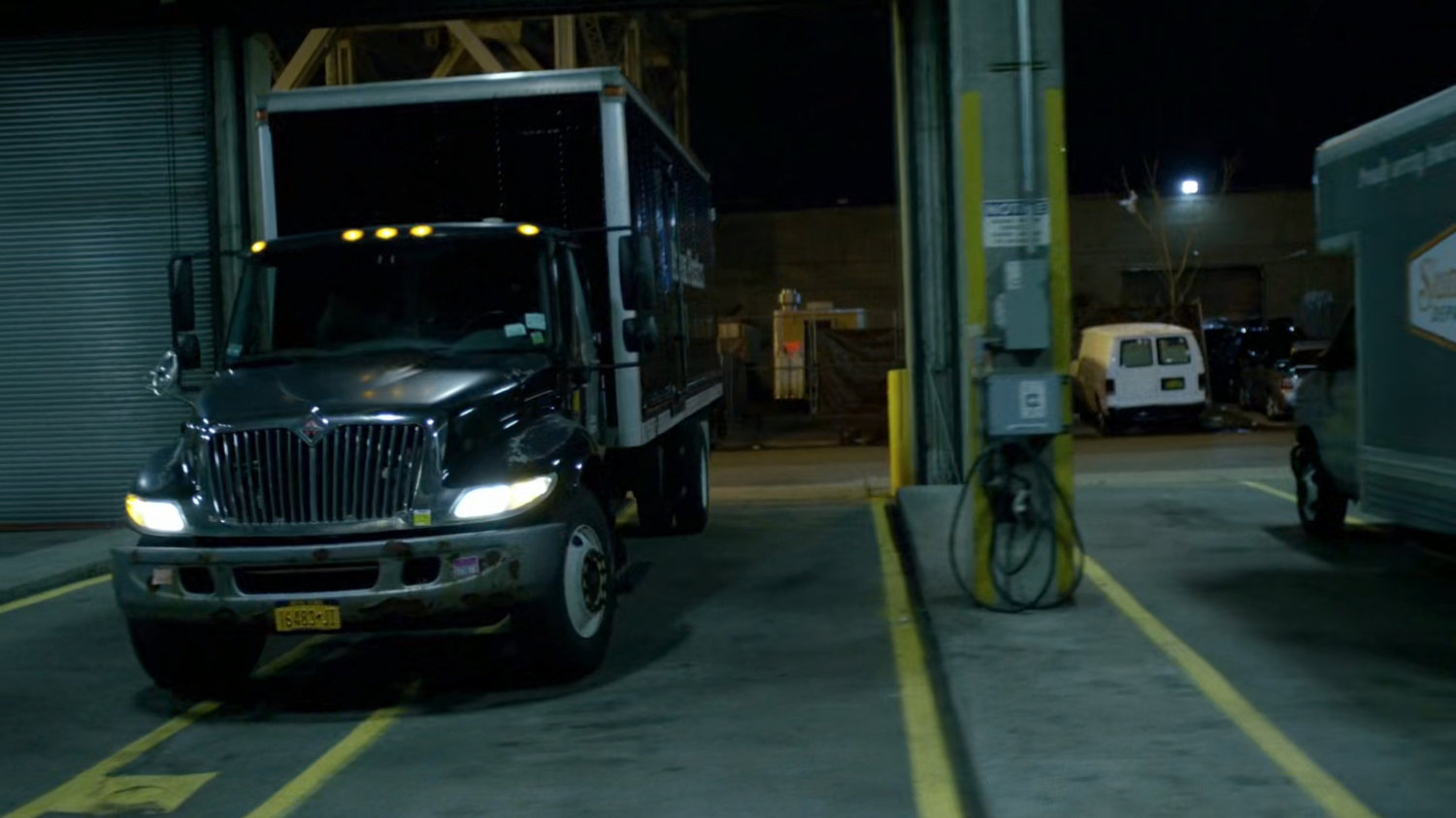 A moving truck pulling into a garage.
