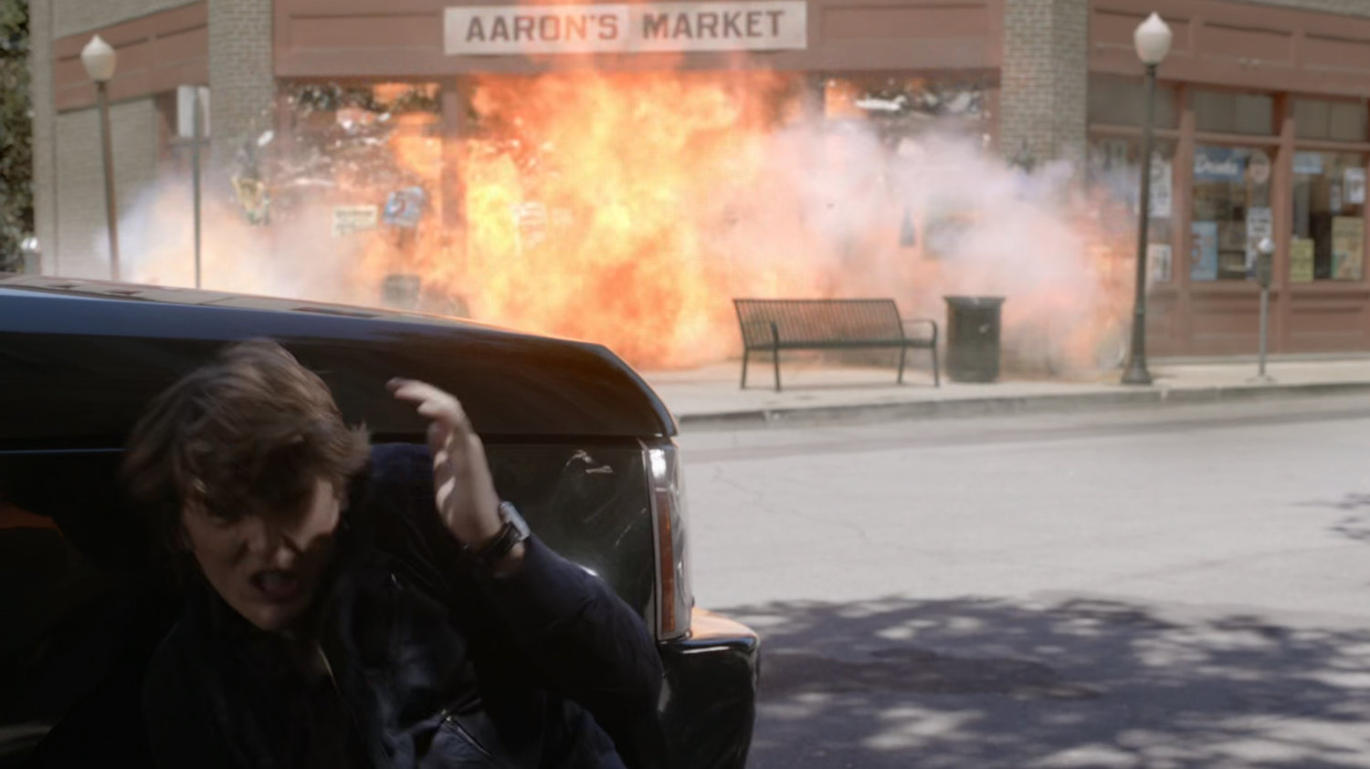 Werner hides behind car as Aaron's Market explodes.
