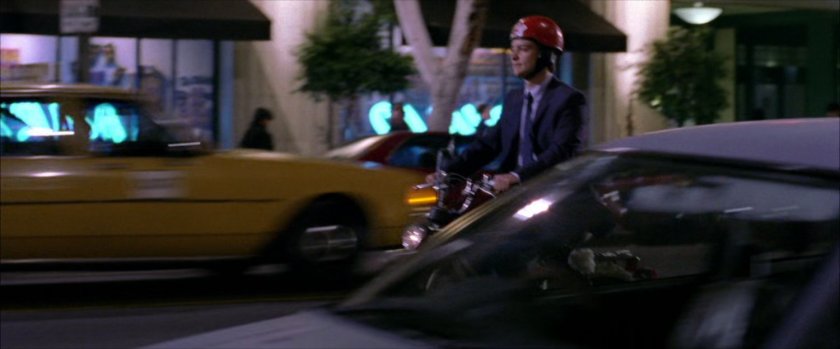 Peter Parker riding on his moped at night.