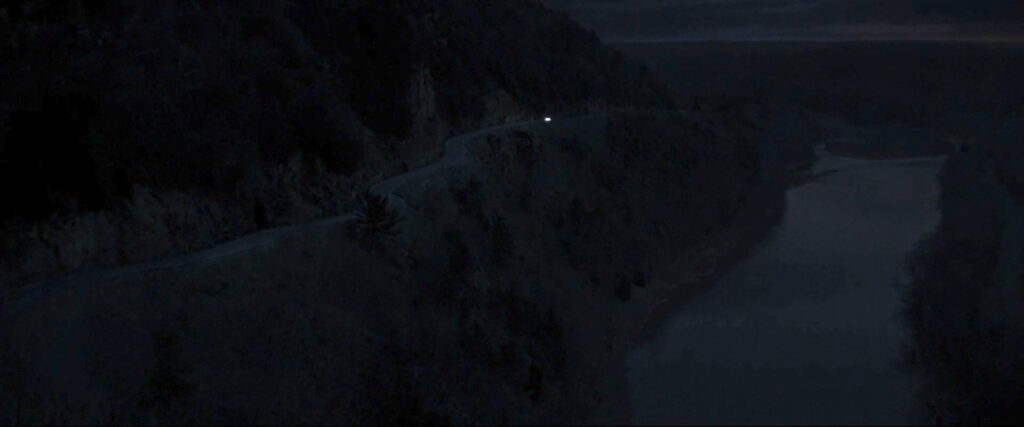 Stephen Strange's car driving along a cliffside road at dusk.
