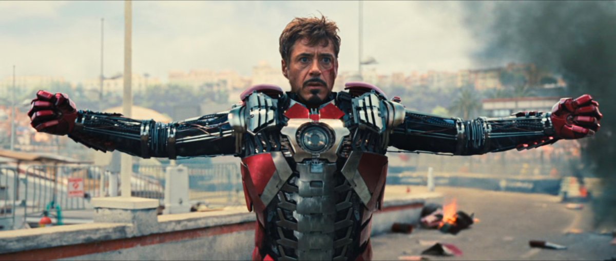 Iron Man raises his arms as his suit assembles onto his body.