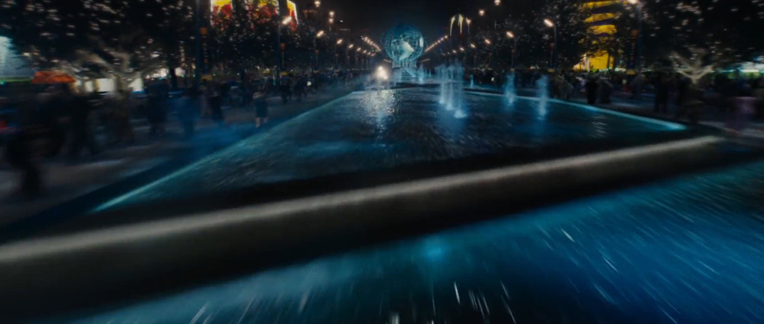 Nighttime exterior of the Stark Expo main entrance and fountains.