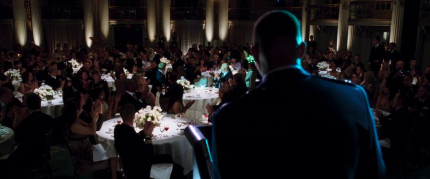 Colonel Rhodes give a speech at an event in a ballroom.