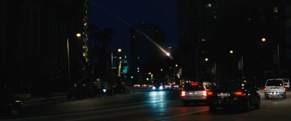 Iron Man rockets over Wilshire Blvd at night.