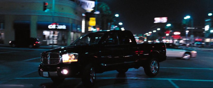 Black pickup makes u-turn on nighttime Los Angeles street.