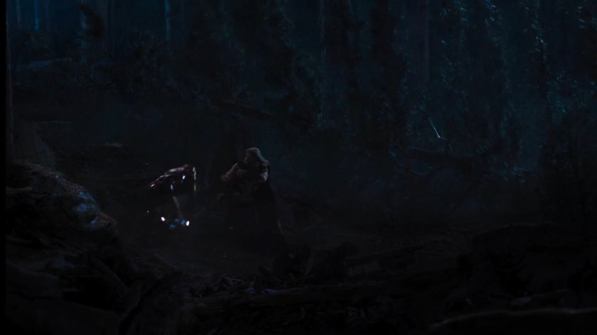 Iron Man and Thor fight in a dark forest.
