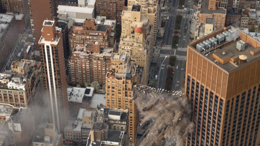 Aerial view of leviathan crashing into side of skyscraper.