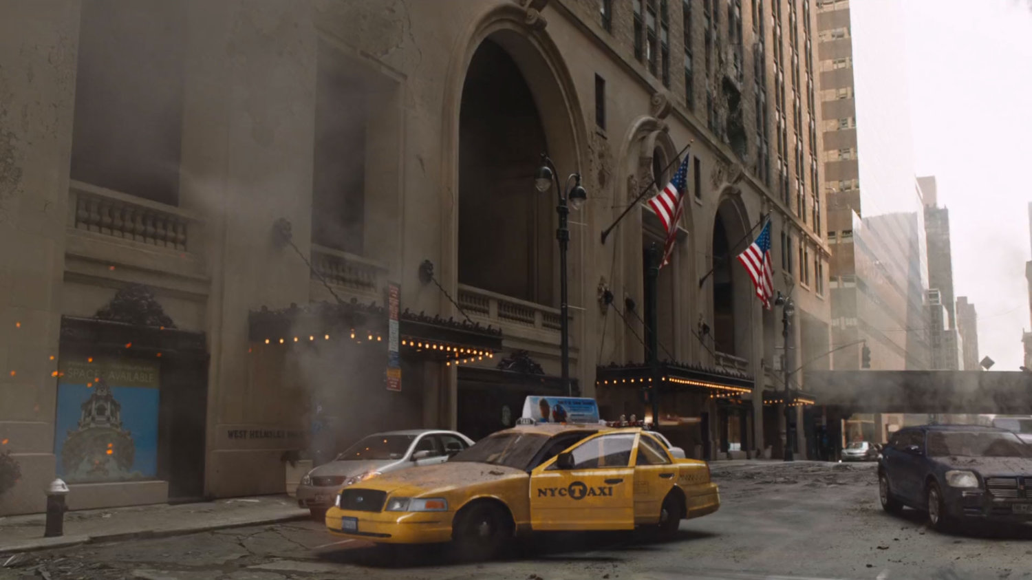 A new York building with American flags and damaged cabs parked in front.