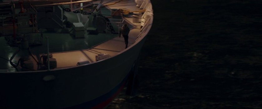 Man walking on stern of boat.