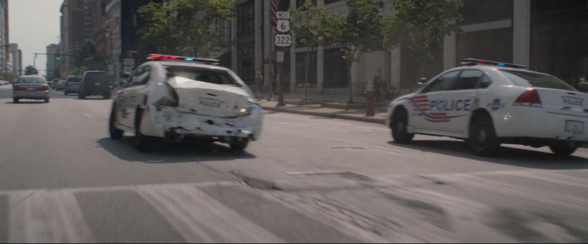 Two police cars pursue.