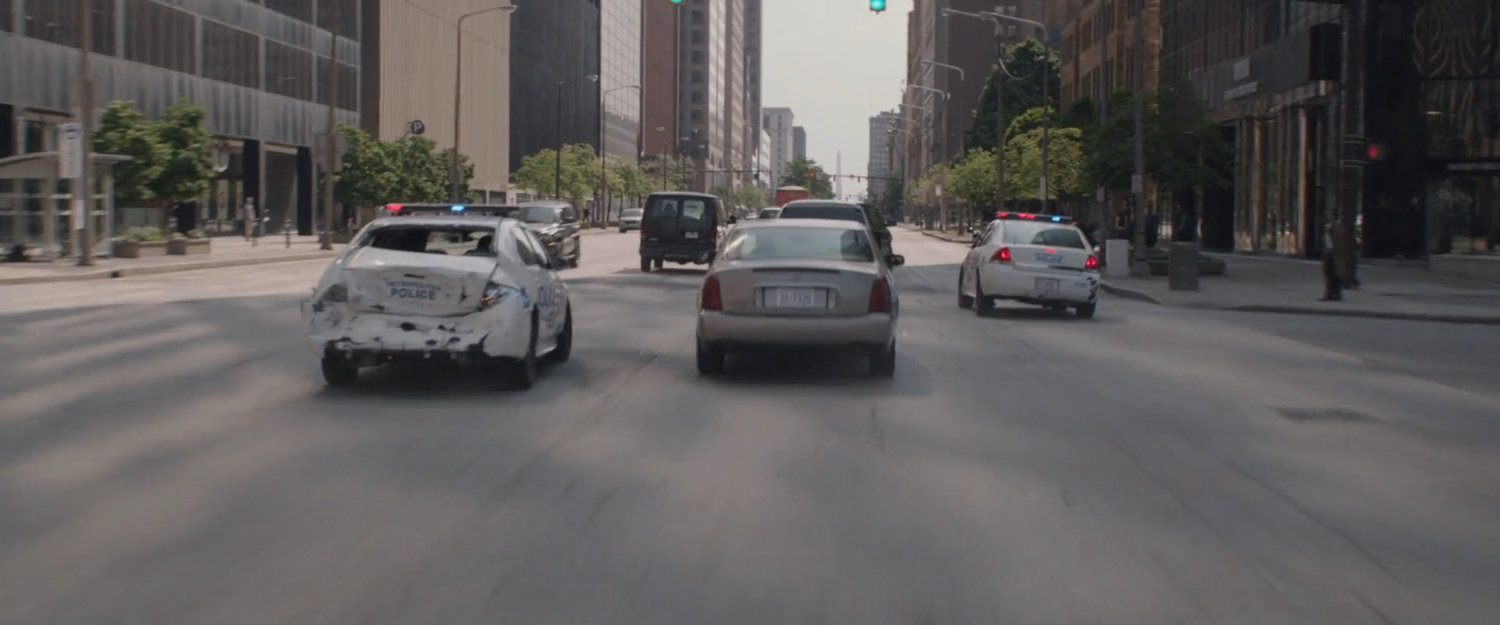 Two police cars in city traffic.
