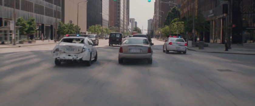 Two police cars in city traffic.