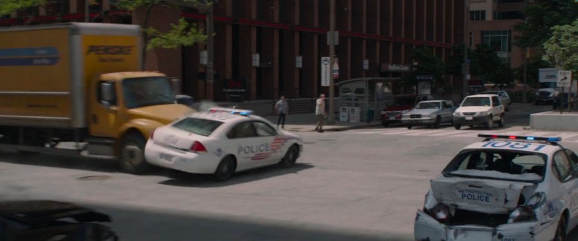 Yellow Penske truck smashes into side of pursuing police car.