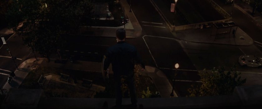 Nighttime shot of silhouetted figure on rooftop looking over Washington DC neighborhood.