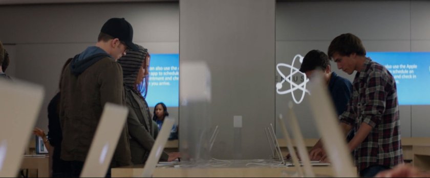 Steve and Natasha looking at laptops inside an Apple store.