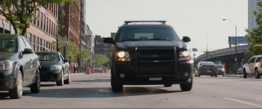 An SUV stops on a street outside a mall.
