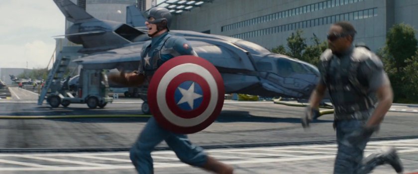 Captain America and the Falcon run across a SHIELD tarmac.