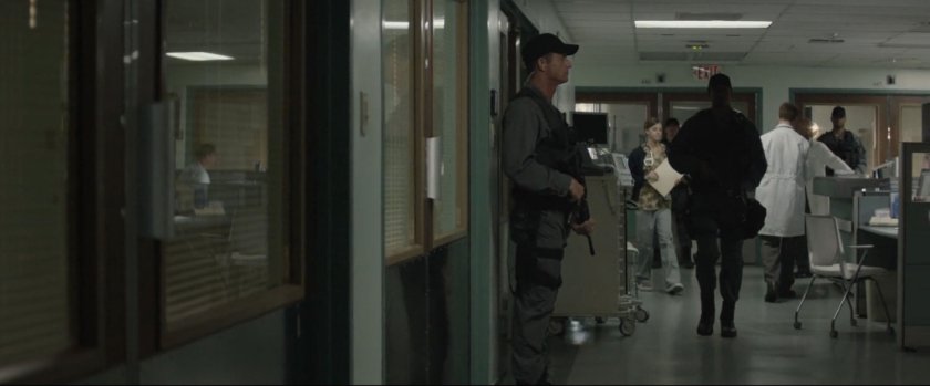 Armed guard standing in hospital hallway.