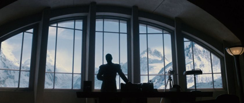 Silhouette of man against windows with Austrian alps outside.