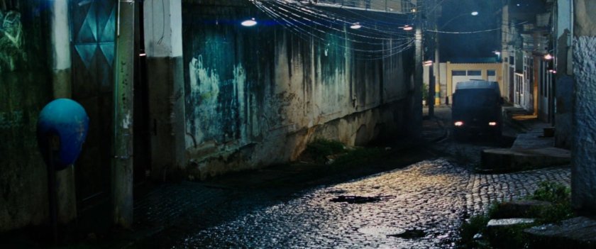 A van driving on a Rio De Janeiro street at night.