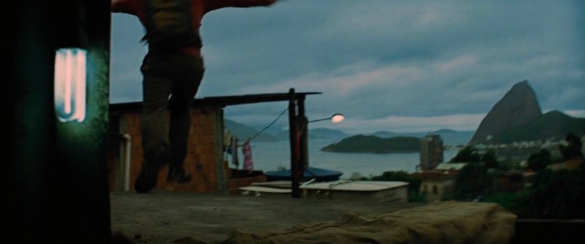 A favela rooftop with a harbor in the background.