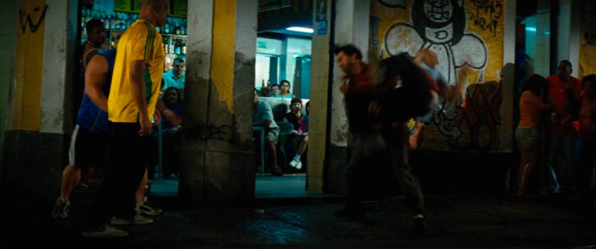 Bruce Banner runs past a favela bar.