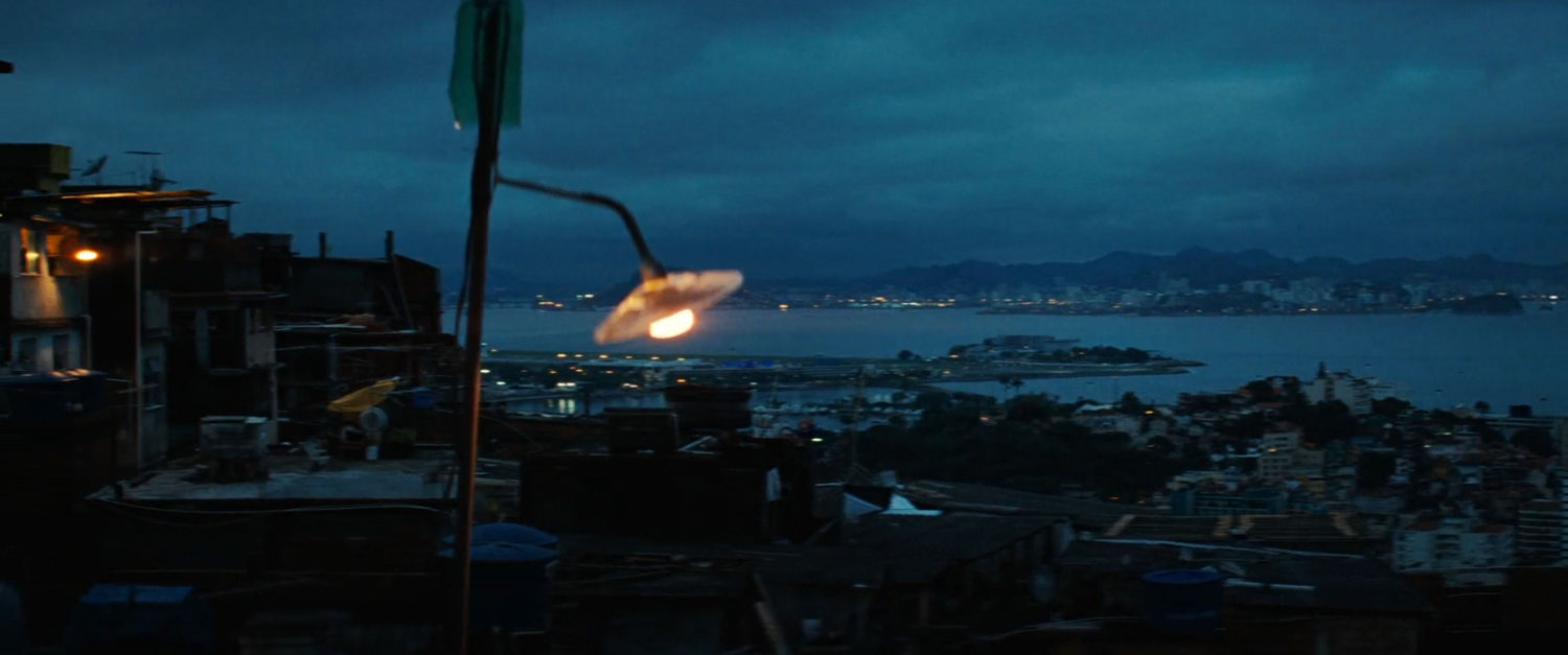A view of the favela rooftops and harbor at dusk.