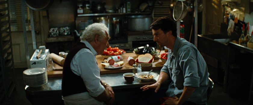 Bruce Banner speaking with Stanley inside pizza parlor.