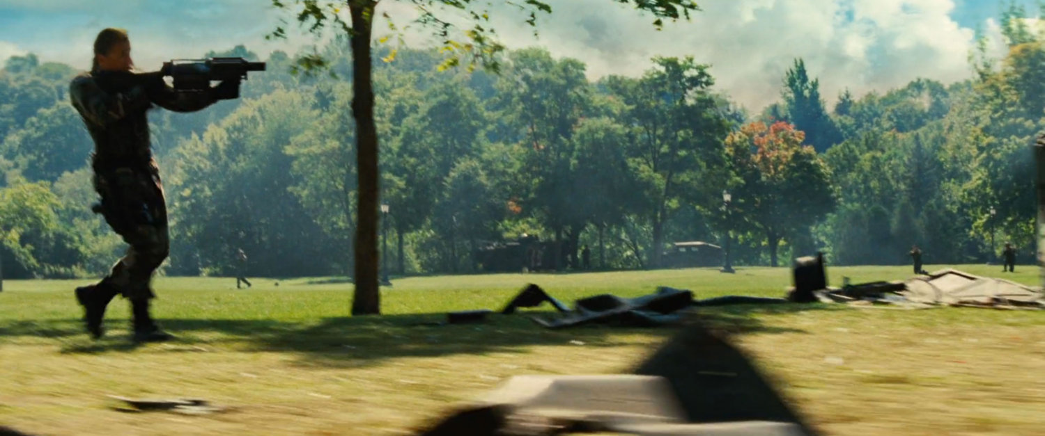 Emil Blonsky running across a park with his gun.