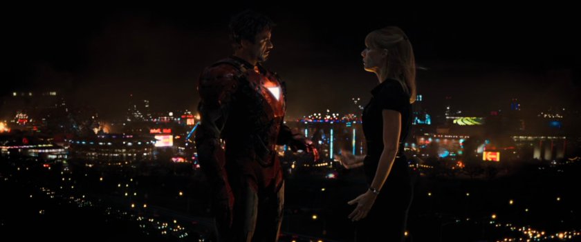 Nighttime shot Tony and Pepper on rooftop with Stark Expo lights in background.
