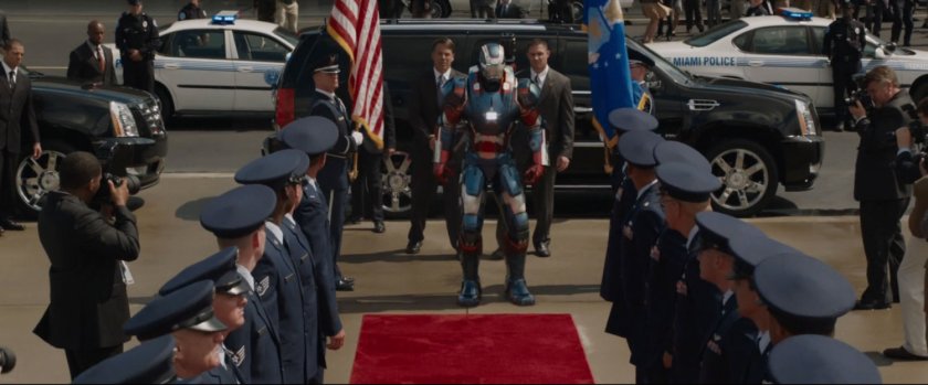 Iron Patriot approaches a red carpet on a tarmac.