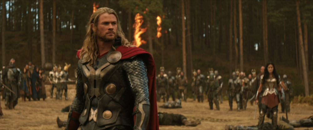 Thor stands outside the woods, with Sif and Asgardian soldiers gathered in the background.