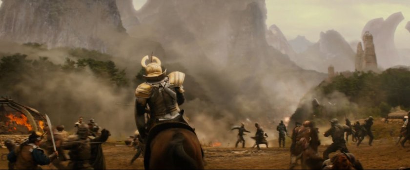 Men on horseback fight on a smokey plain.