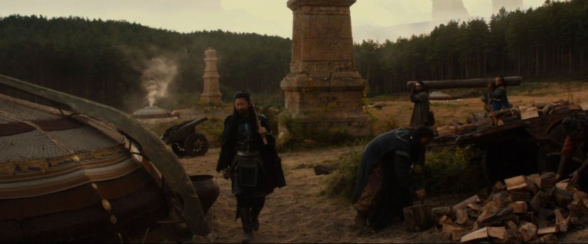 Hogun wanders past some ruins and a tent.