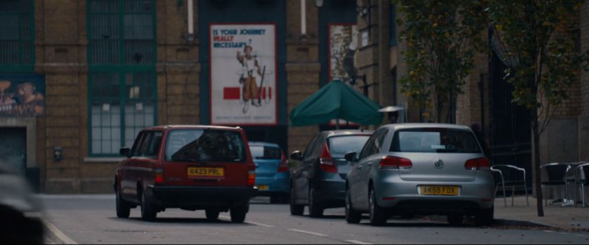 A red car drive down a London street.