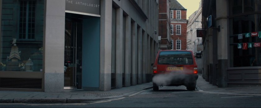 A red car drive into an alley.