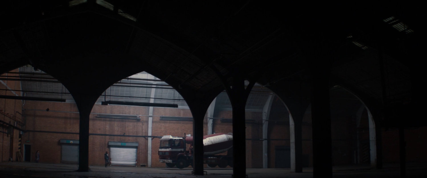 Interior of warehouse with cement truck inside.