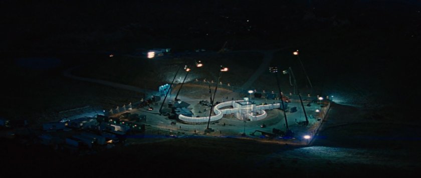 Nighttime aerial of SHIELD encampment around crater.