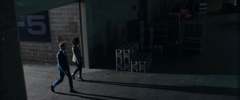 Monica Rambeau and Director Hayward enter a dark warehouse-like room in SWORD.