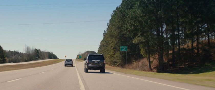 Black SUV taking exit from highway.