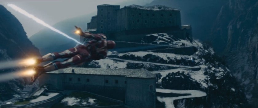 Iron Man flies past a giant castle on top of a snowy mountain.
