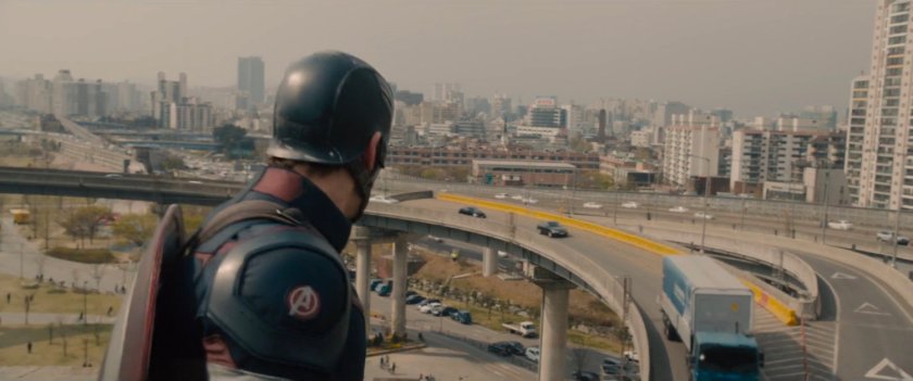 Captain America looking at traffic on bridge.