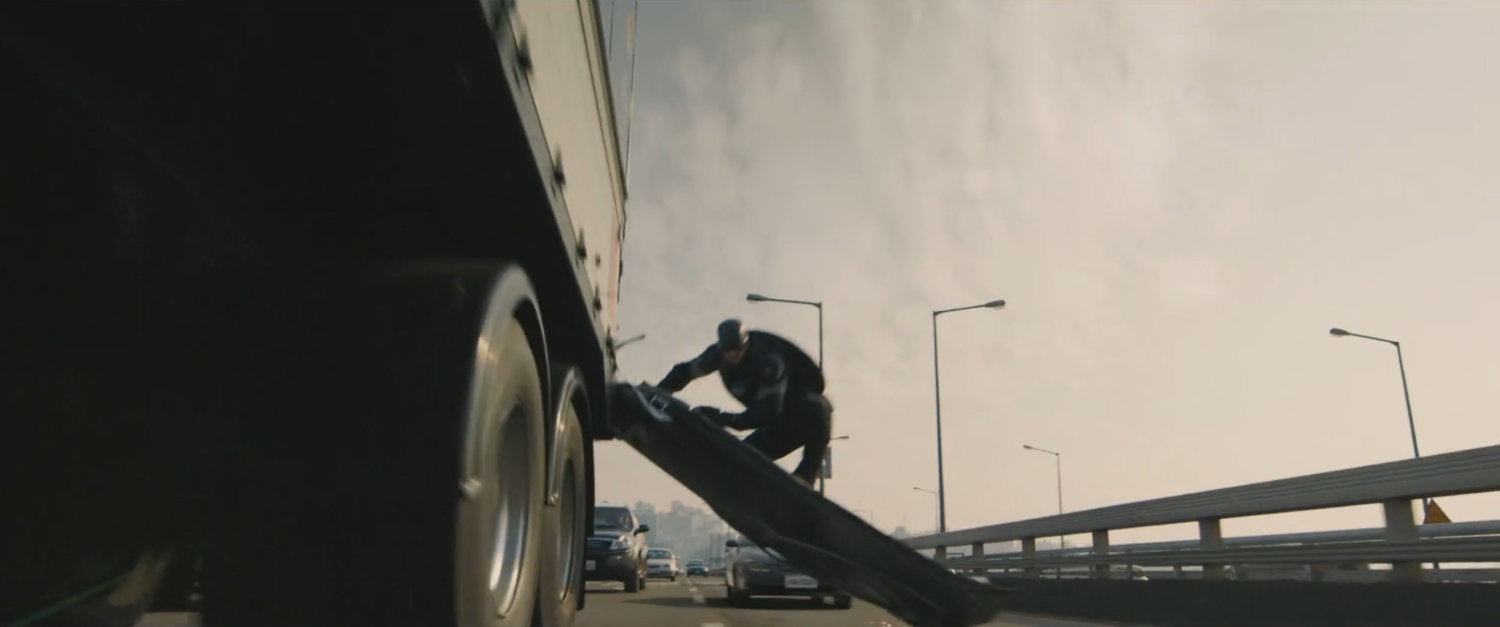 Captain America hanging onto truck.